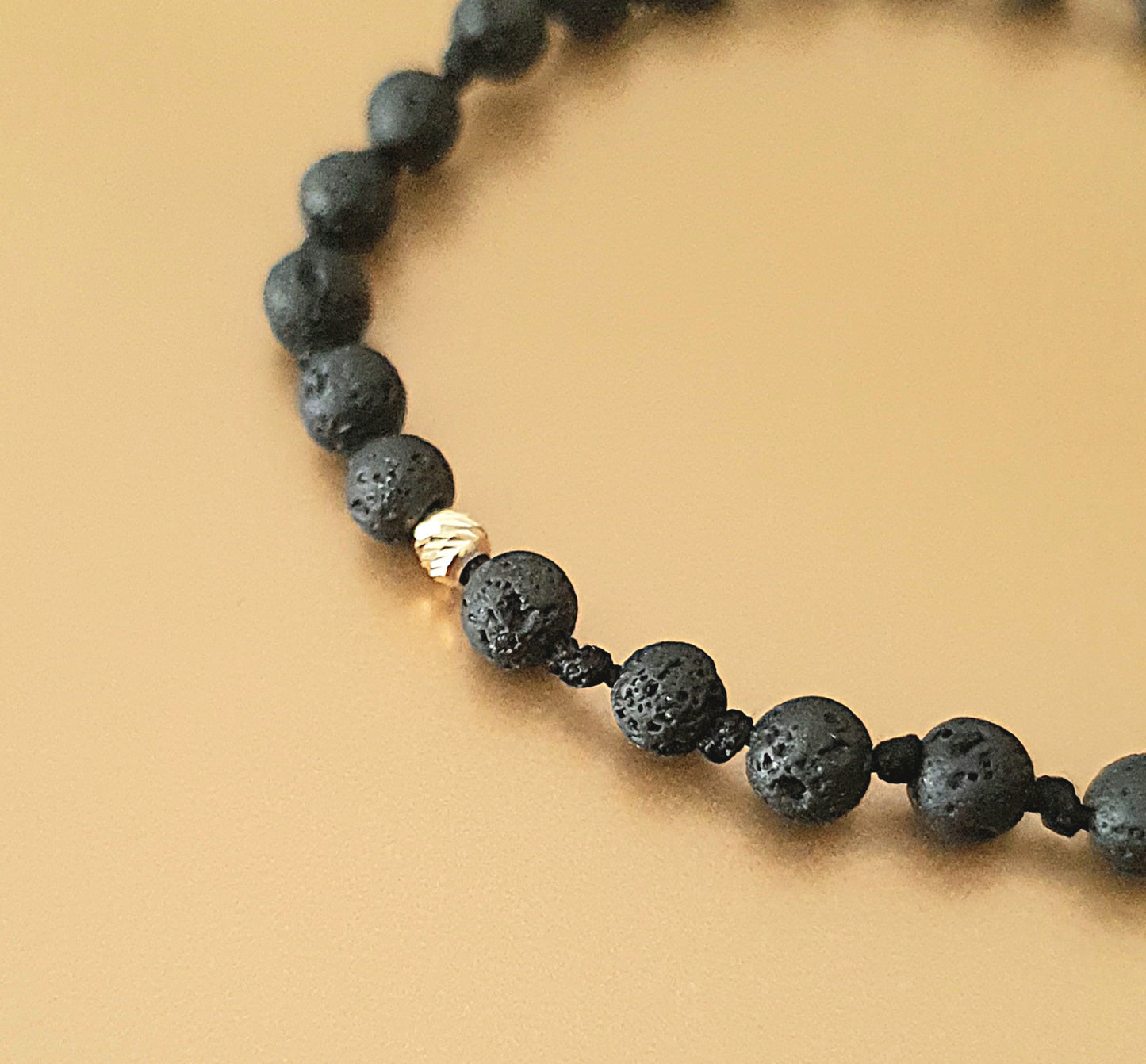 Apyrankės iš aukso karoliukų ir natūraliais lavos akmenukais